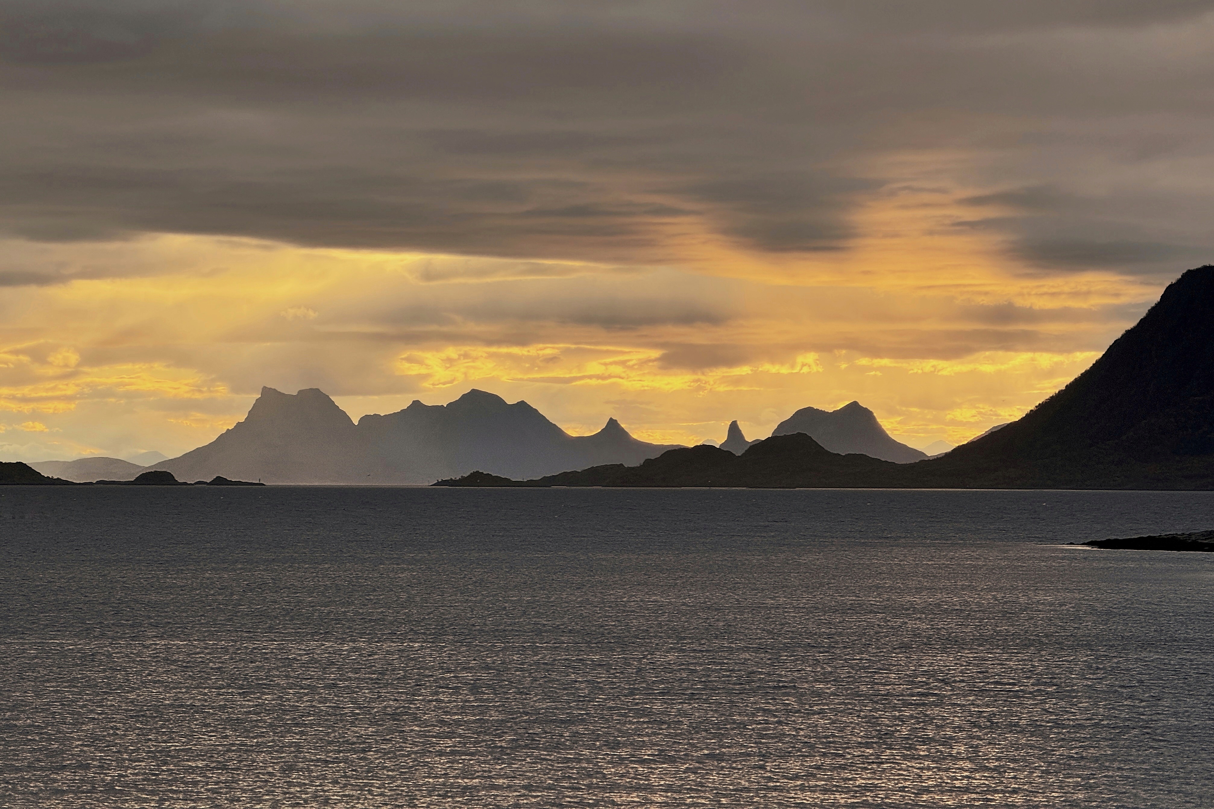 Montagnes et mer sous un ciel doré